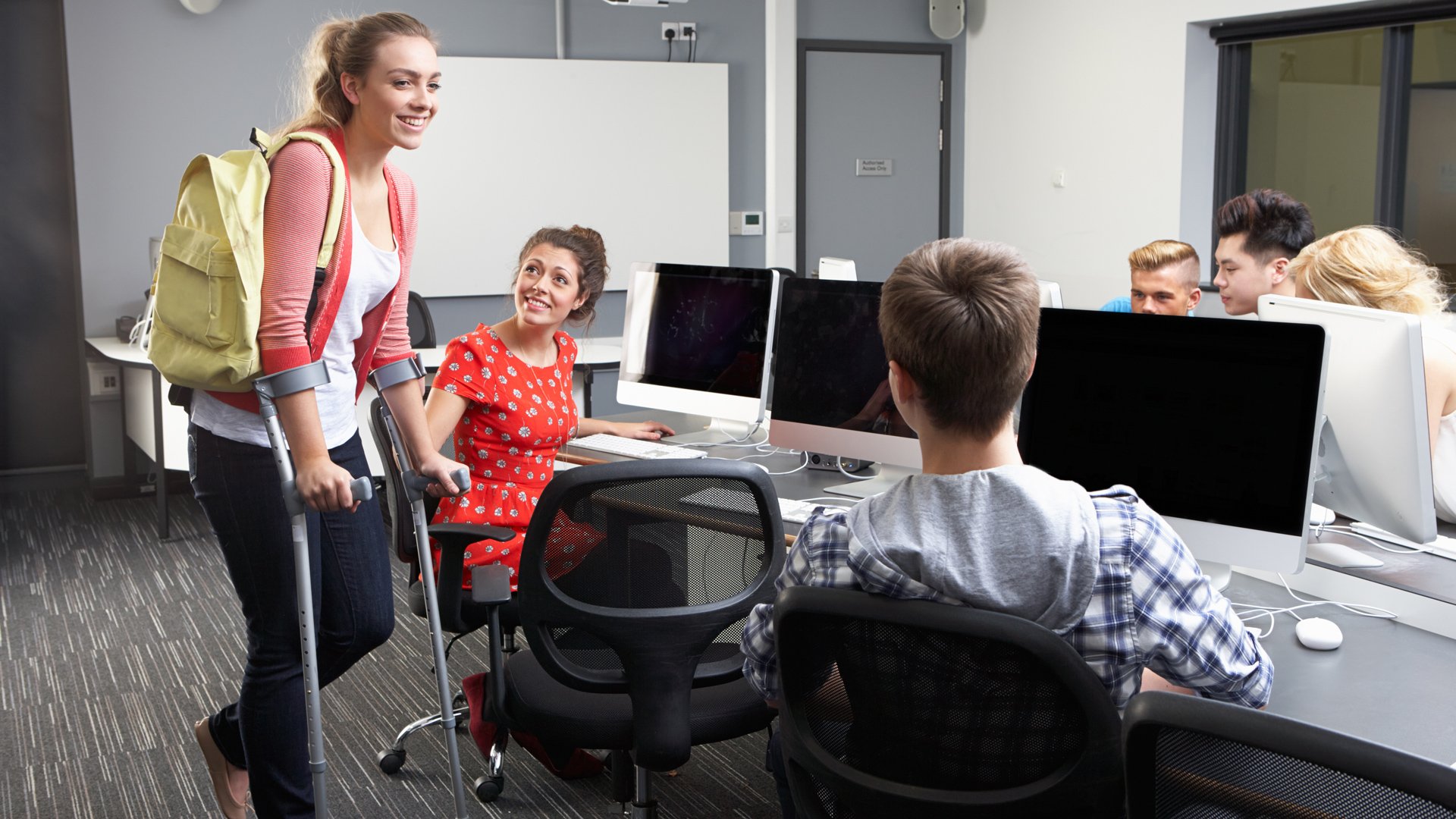 injured person approaches a group of people on computers