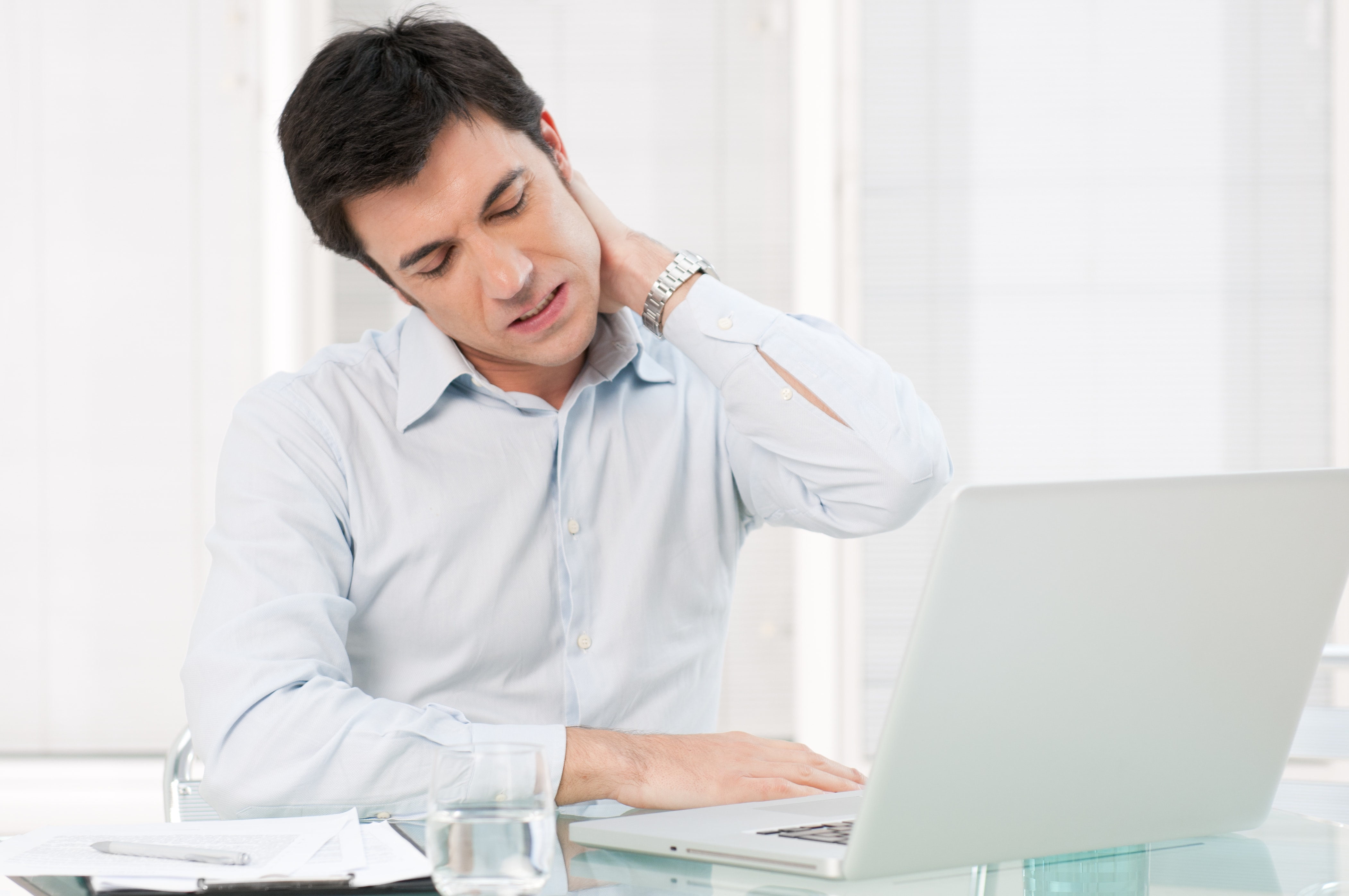 man with a sniff neck while working on a computer