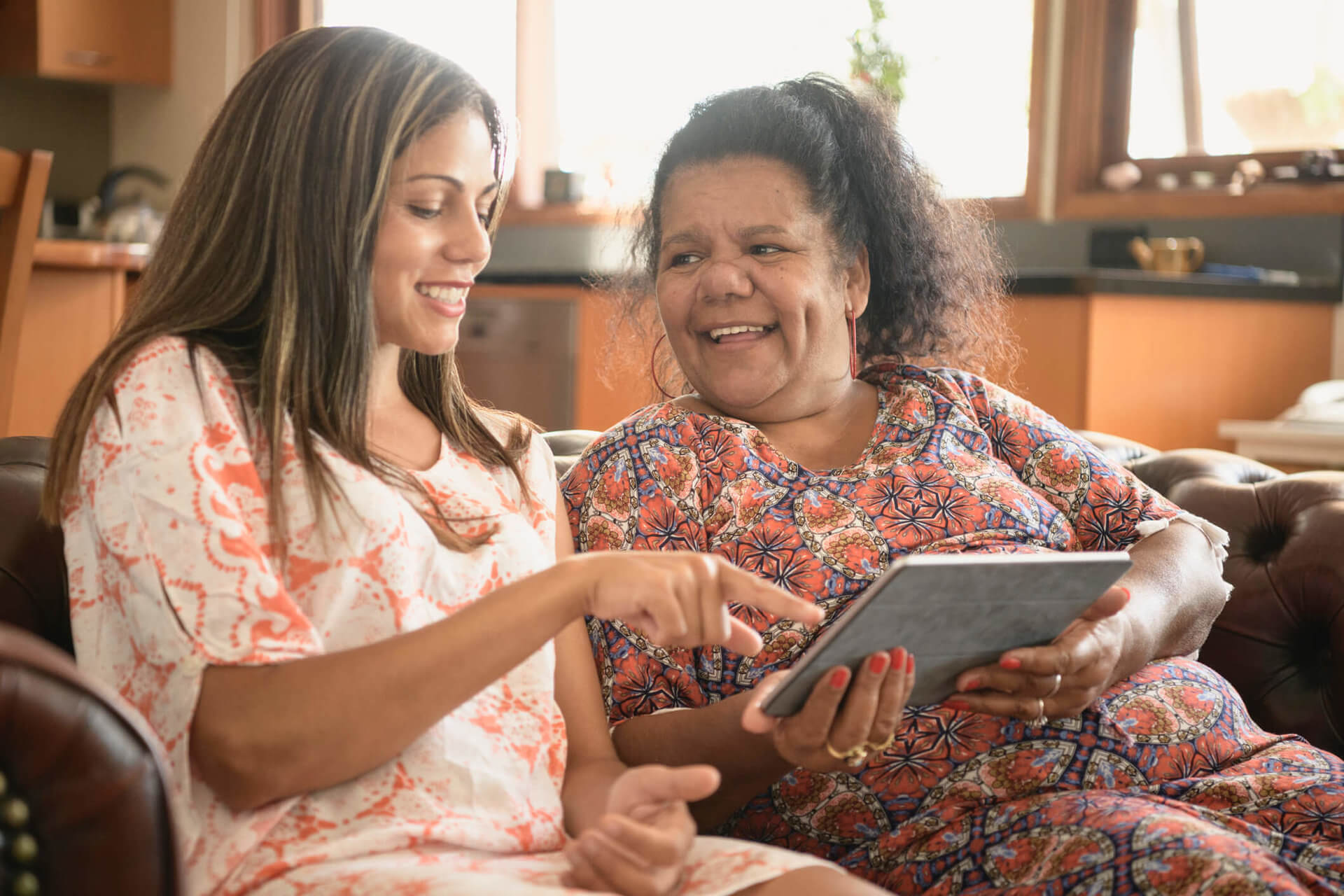 two woman discussing something on an ipad