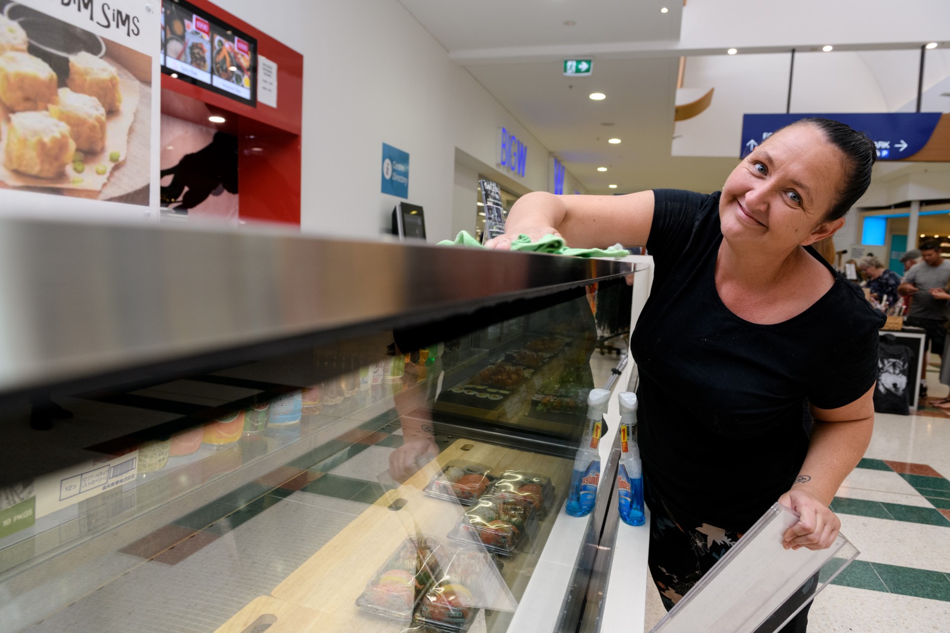 Lesley smiles at the counter of her workplace