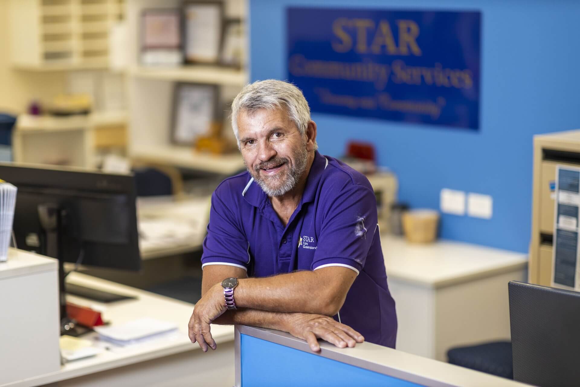 man leaning on desk smiling