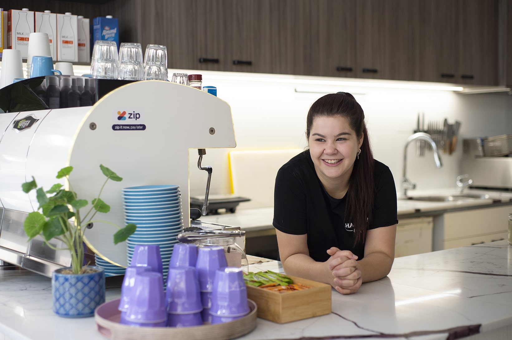 DES participant Jess at the counter of a hair salon coffee shop