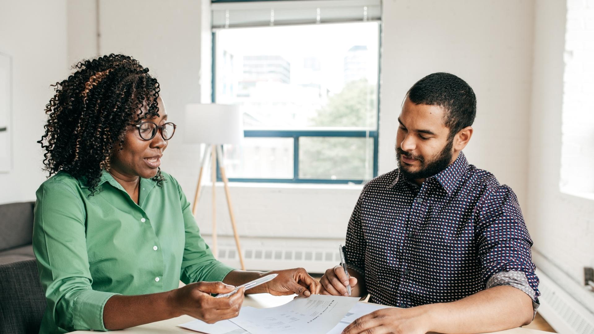 Two people discussing paperwork