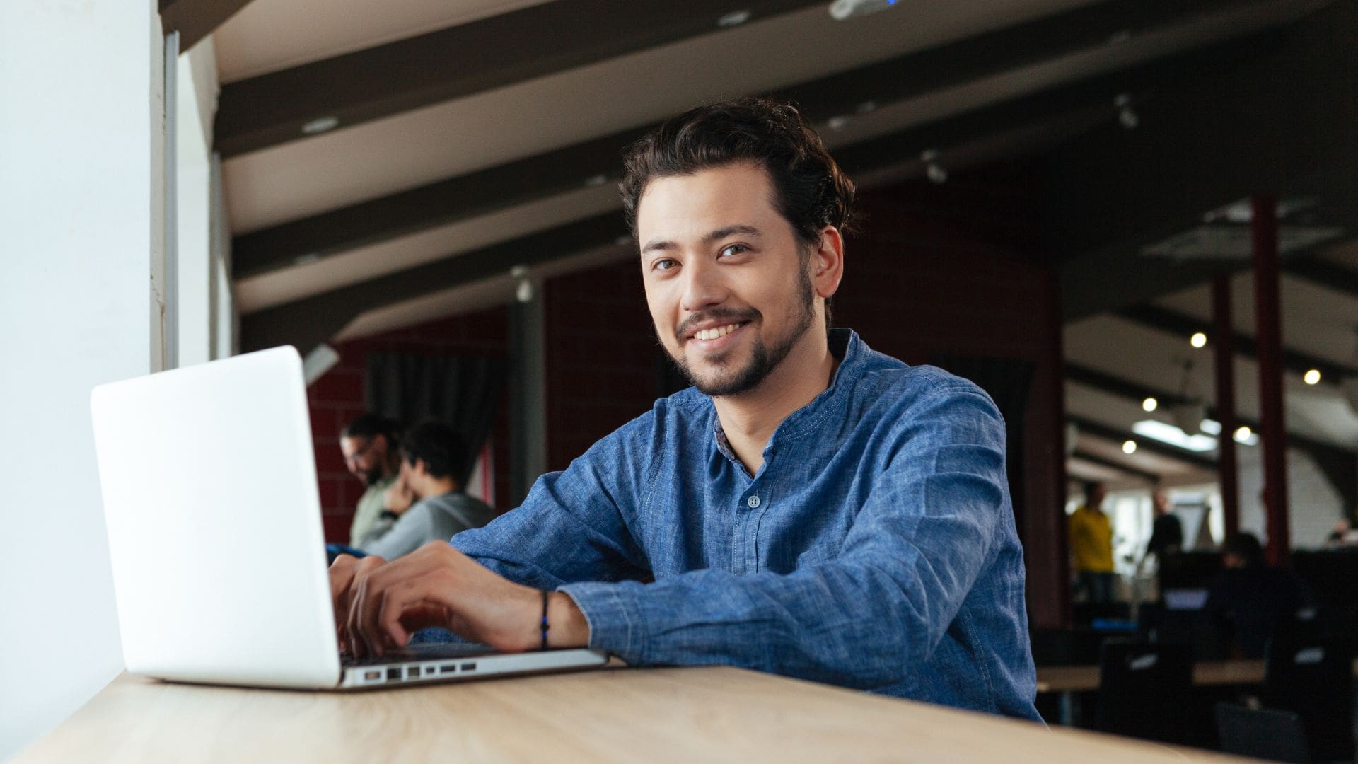 Man smiling while using a laptop