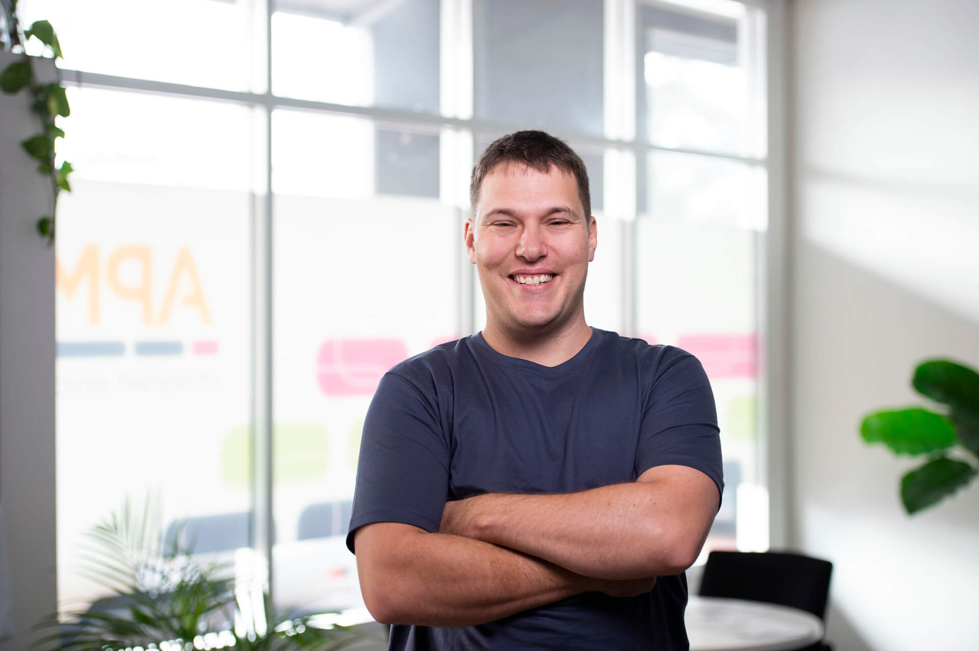 man standing with arms folded smiling