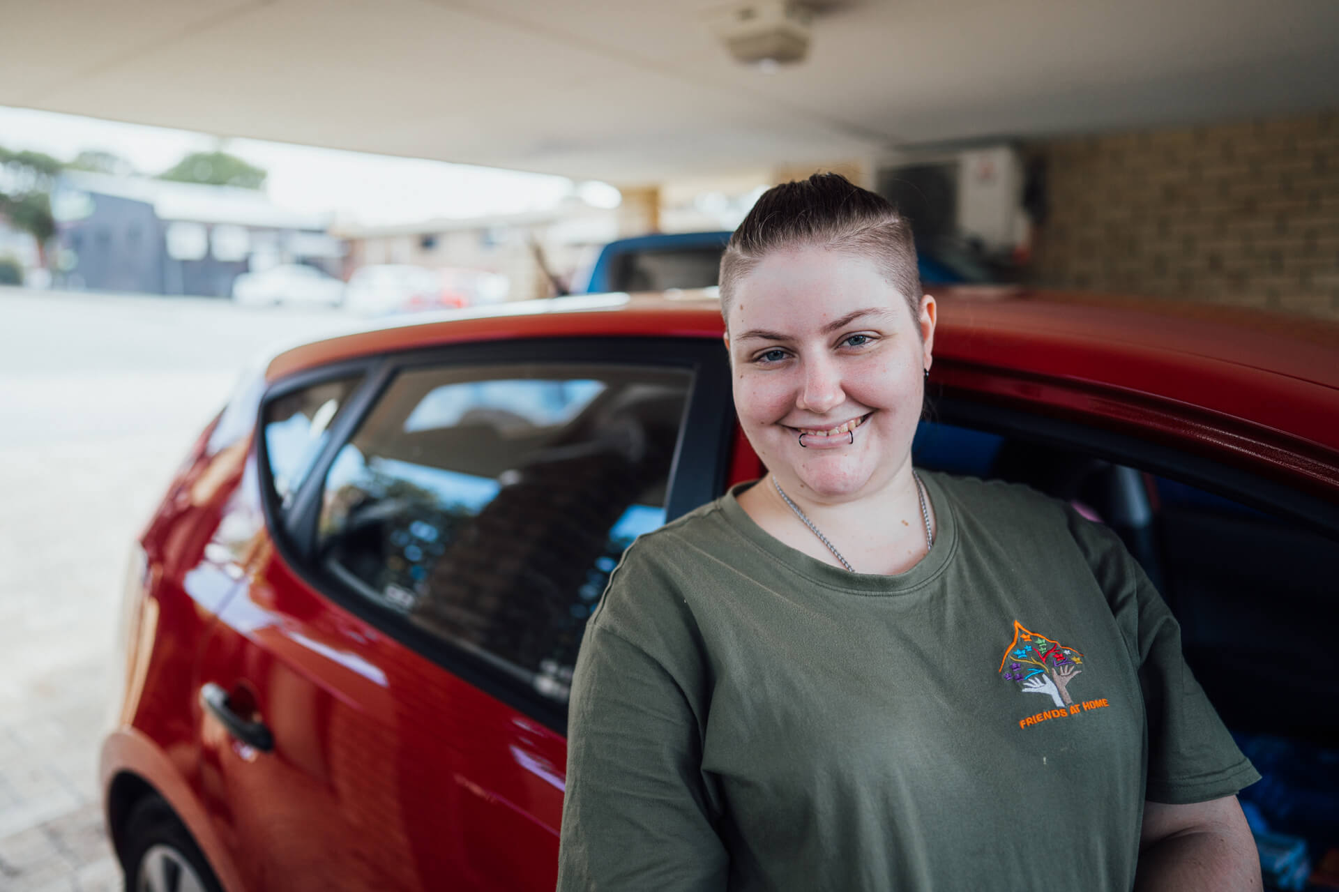 DES participant Alexi smiling outside next to a car