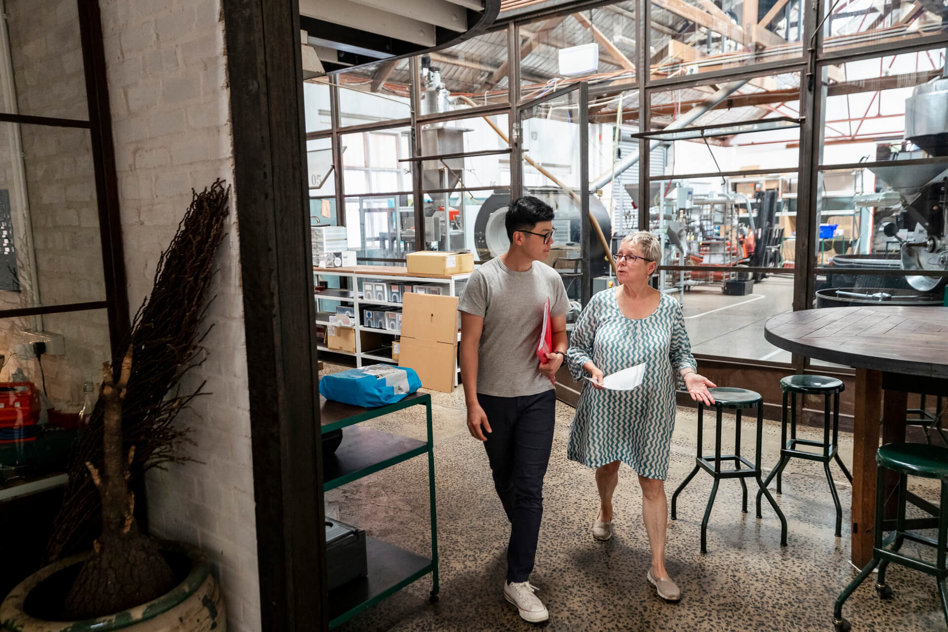 man and a woman walking through a metal works store