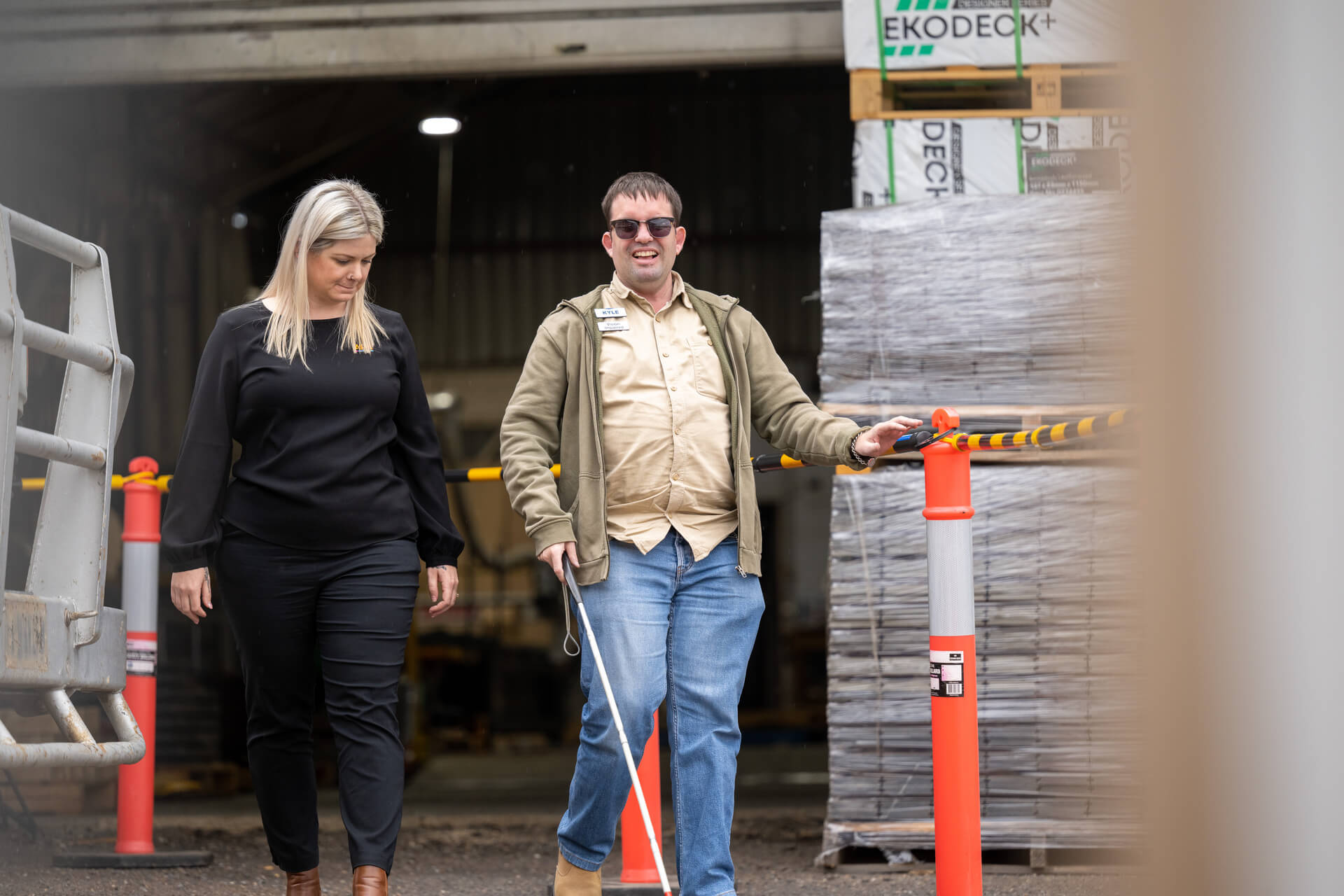 Woman walking next to blind person with stick