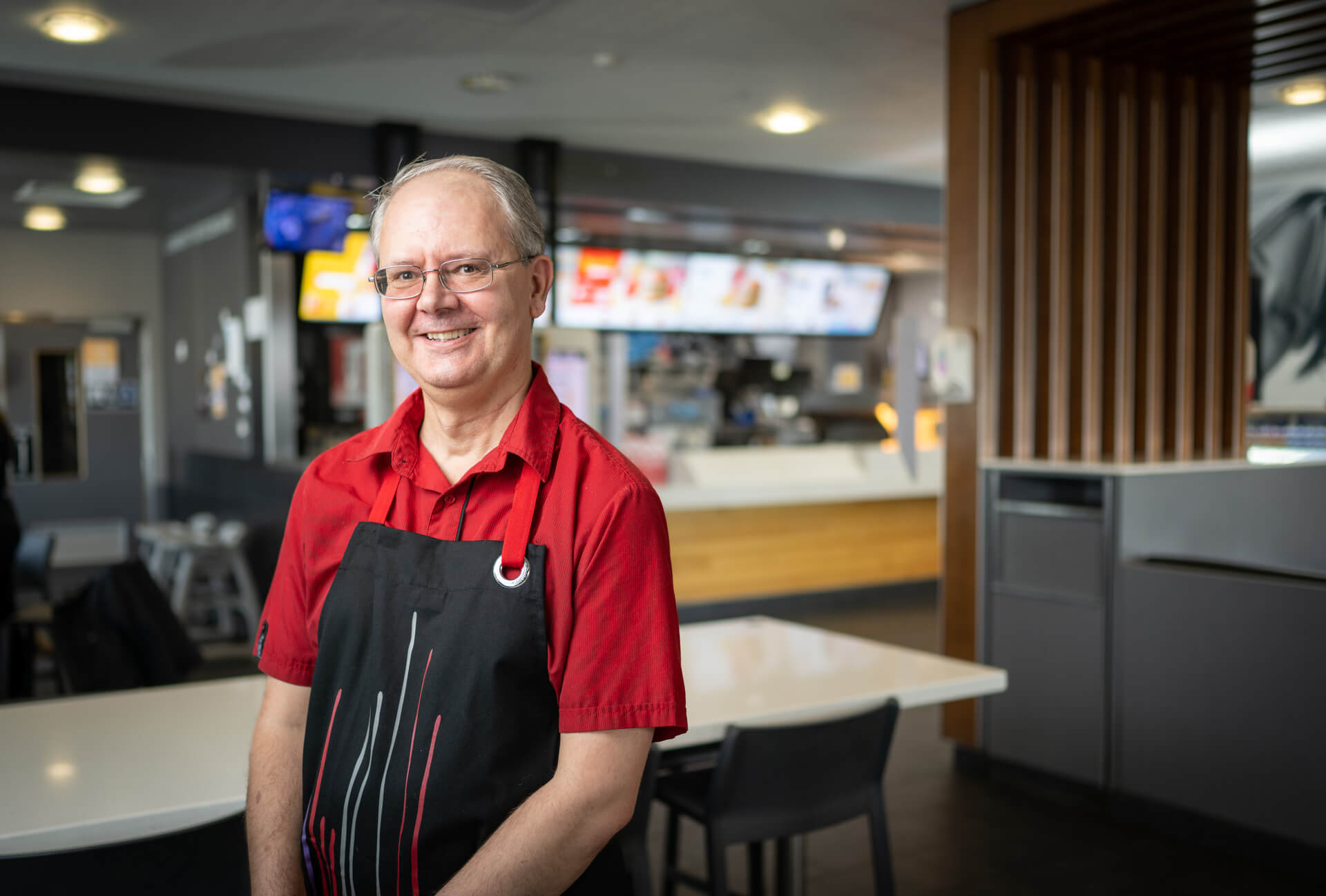 Darren smiles in an apron and McDonald's uniform.