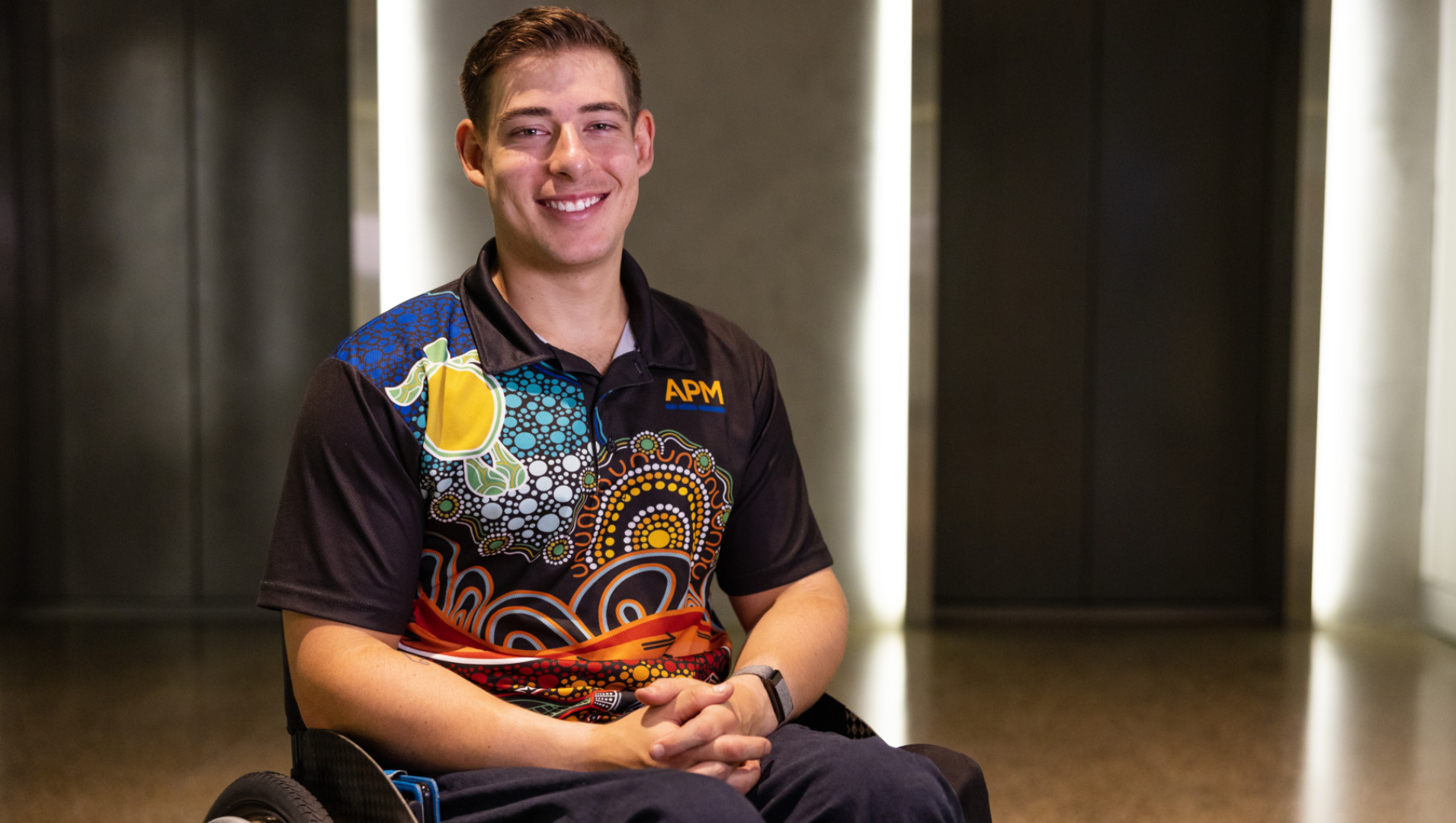 Tristan from APM Communities in a wheelchair and APM polo