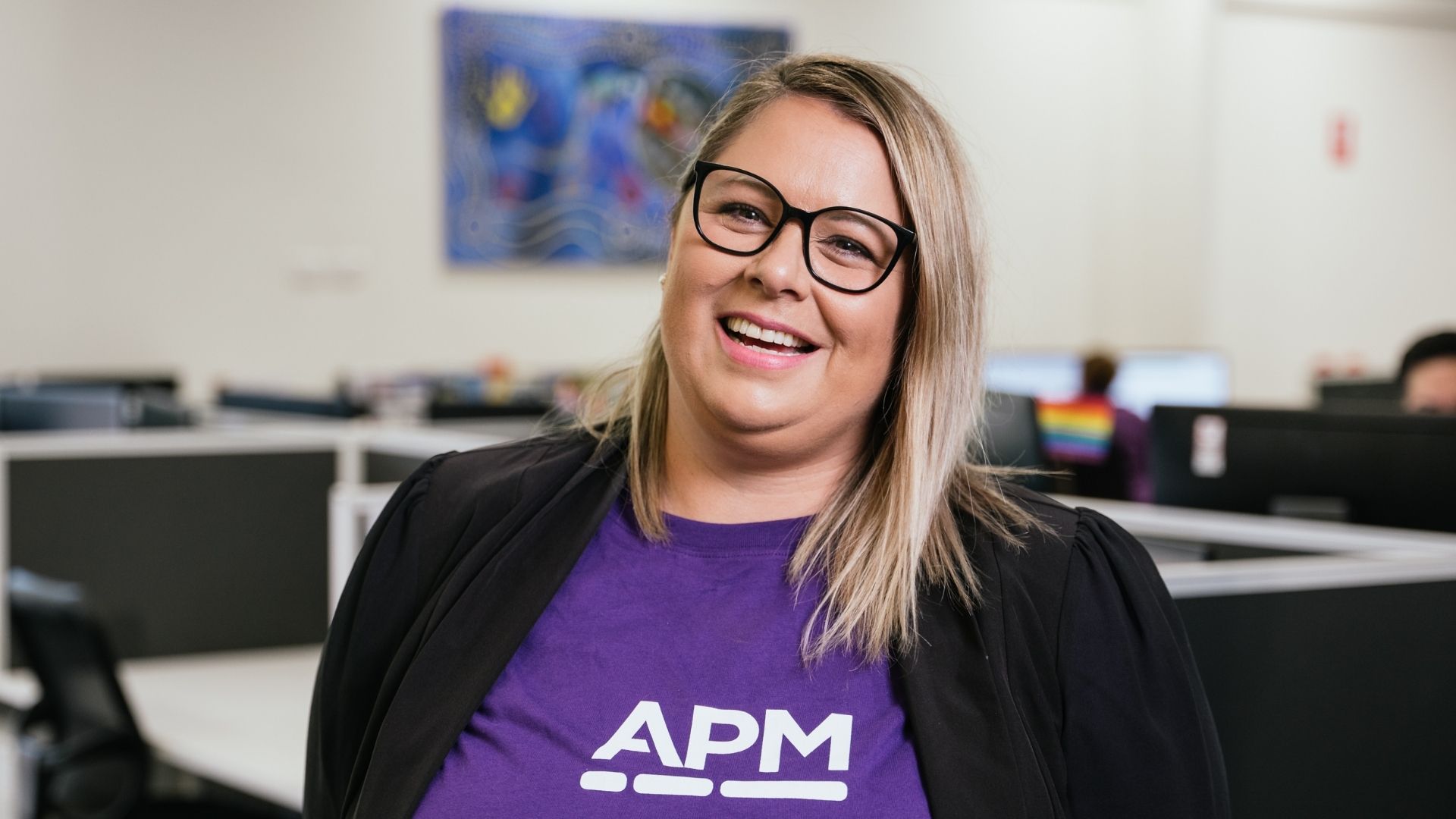 APM employee smiling with purple APM top 