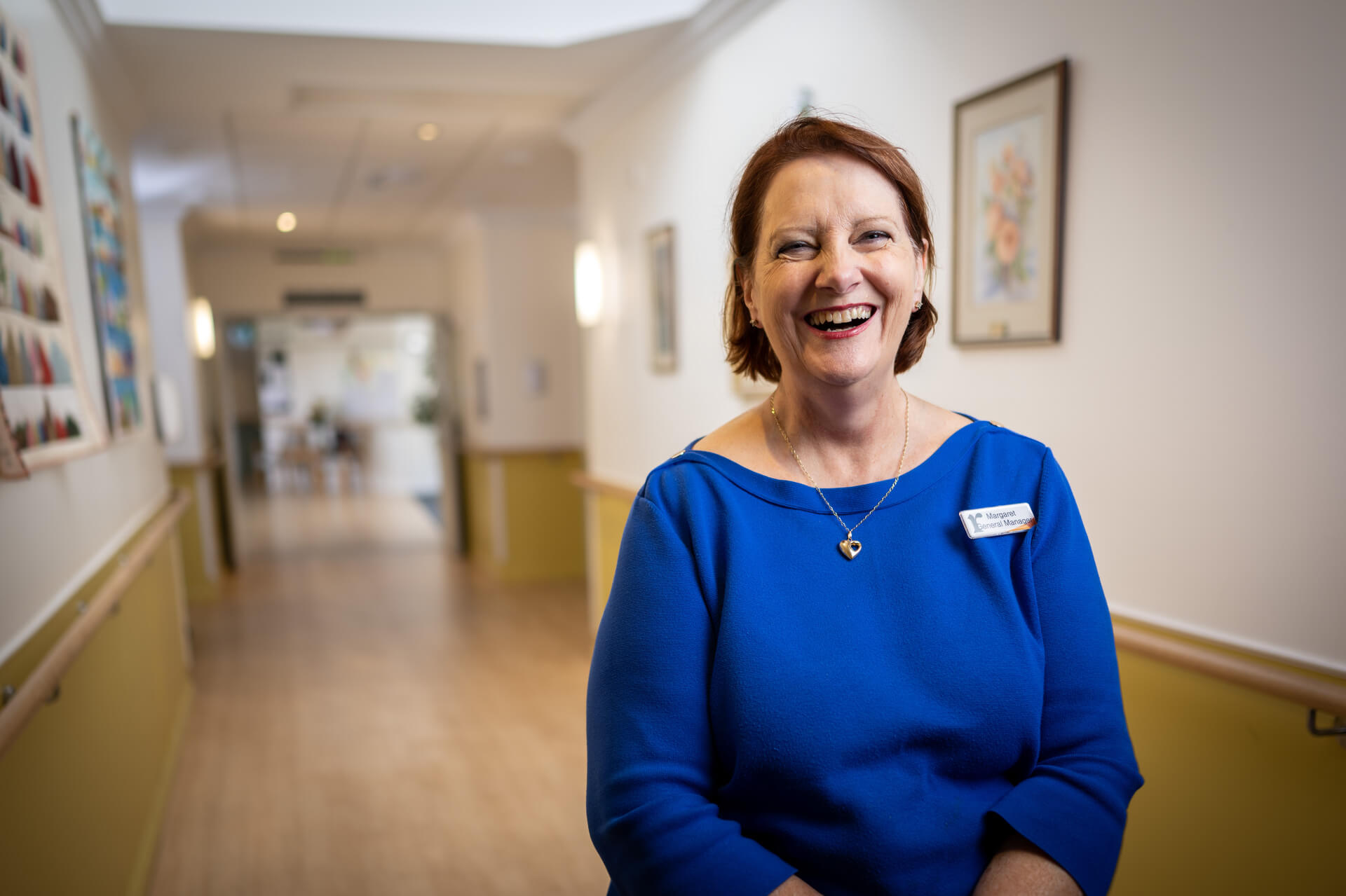 Employer Margaret smiles in a corridor