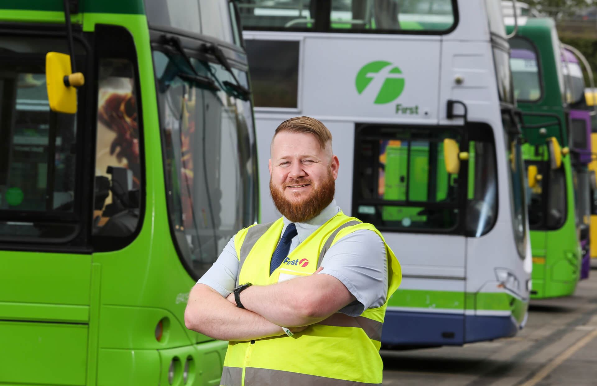 David smiles in high vis top near buses