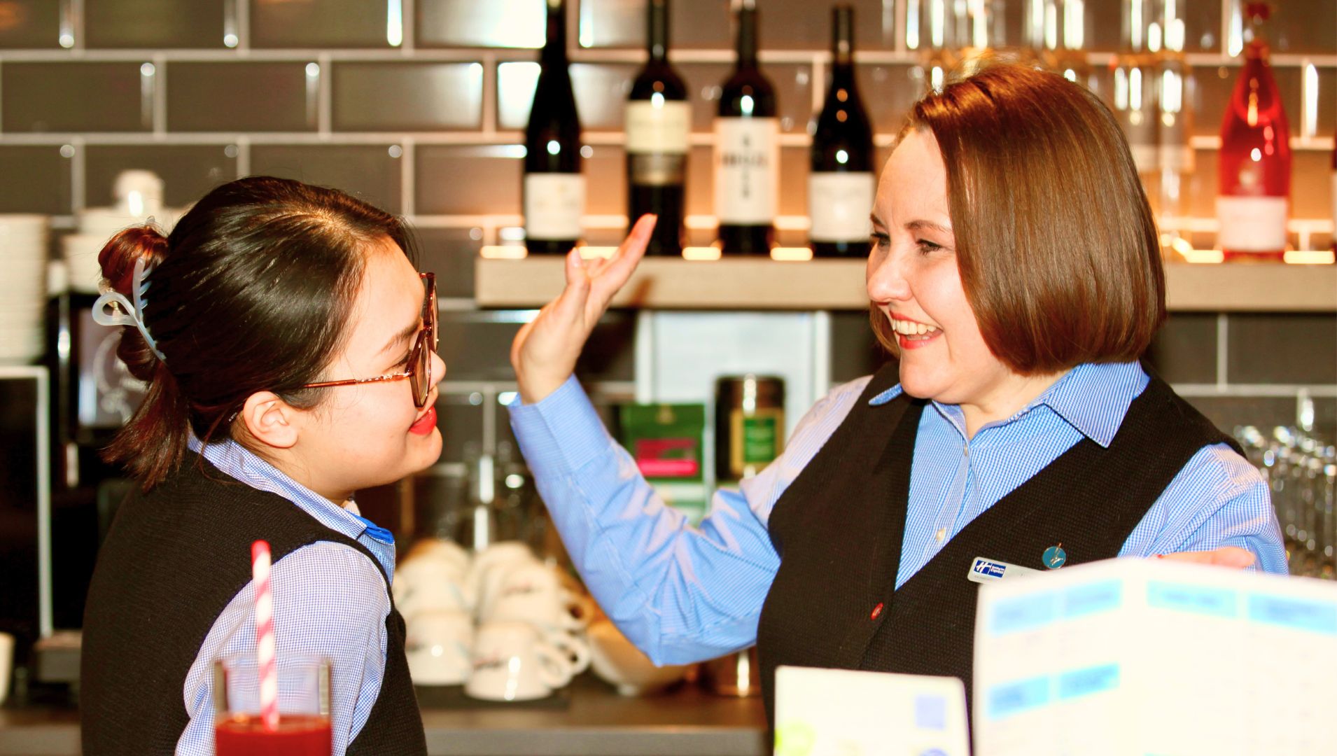 Olena at work wearing hotel staff uniform and standing in the reception