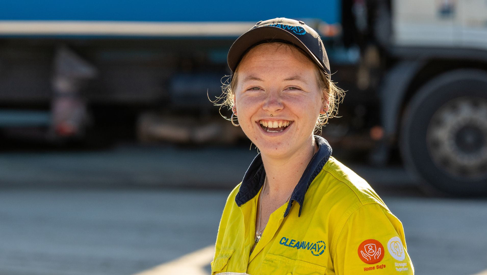 A young female participant smiles in a truck yard