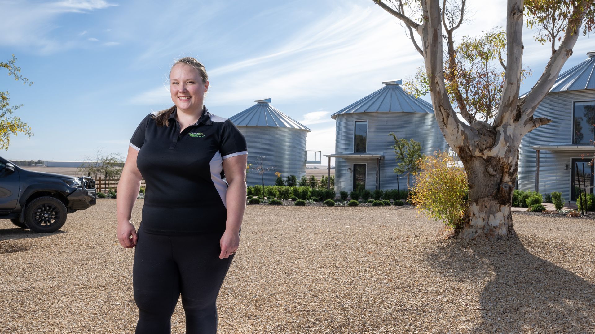 DES participant Ngaire in a black top outside rural buildings