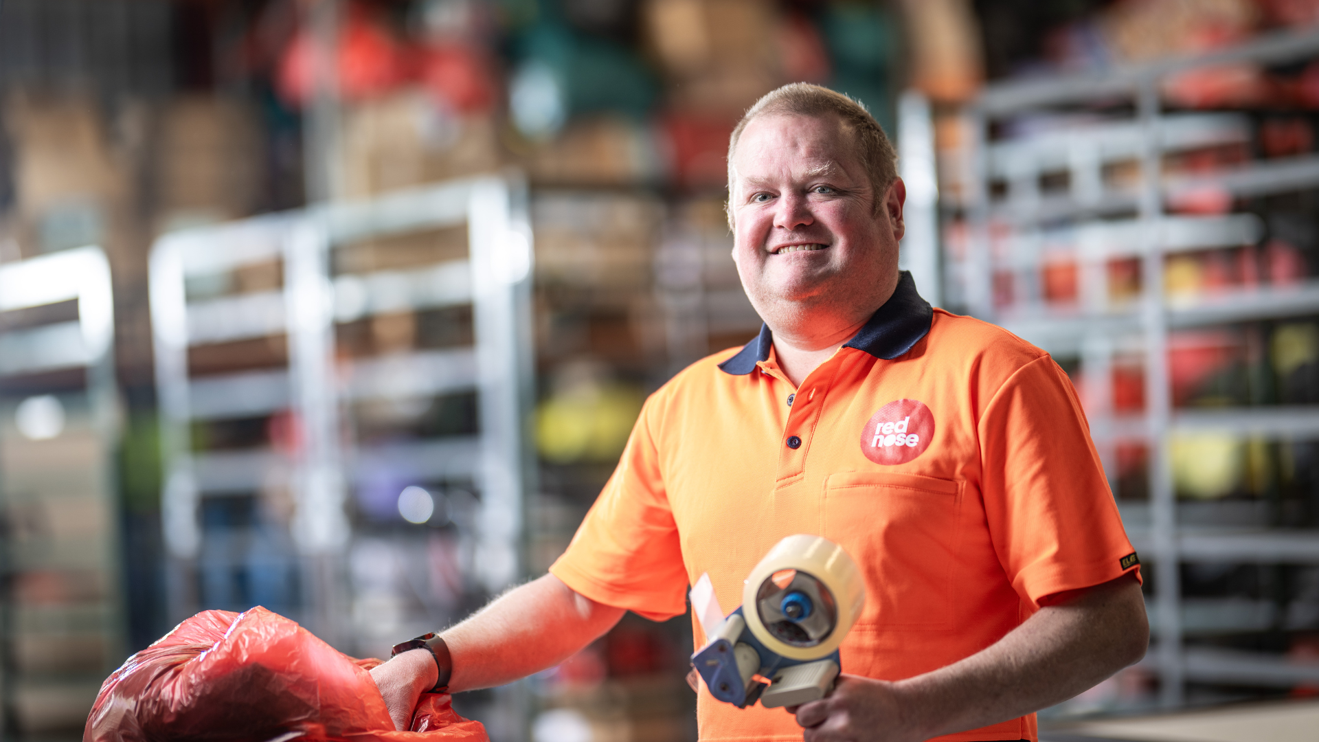 DES participant Eric smiles as he works in a warehouse 