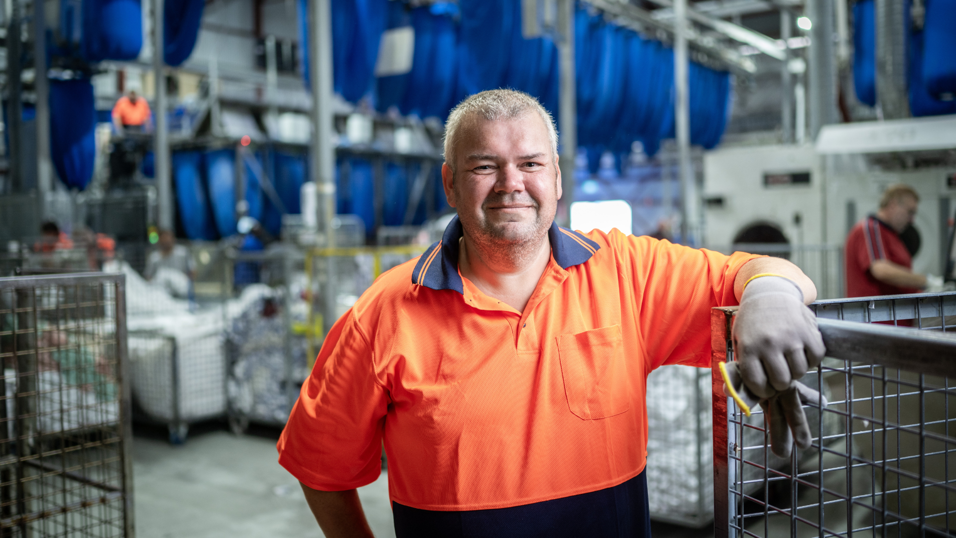 DES participant Geoff smiles as he works in a warehouse 