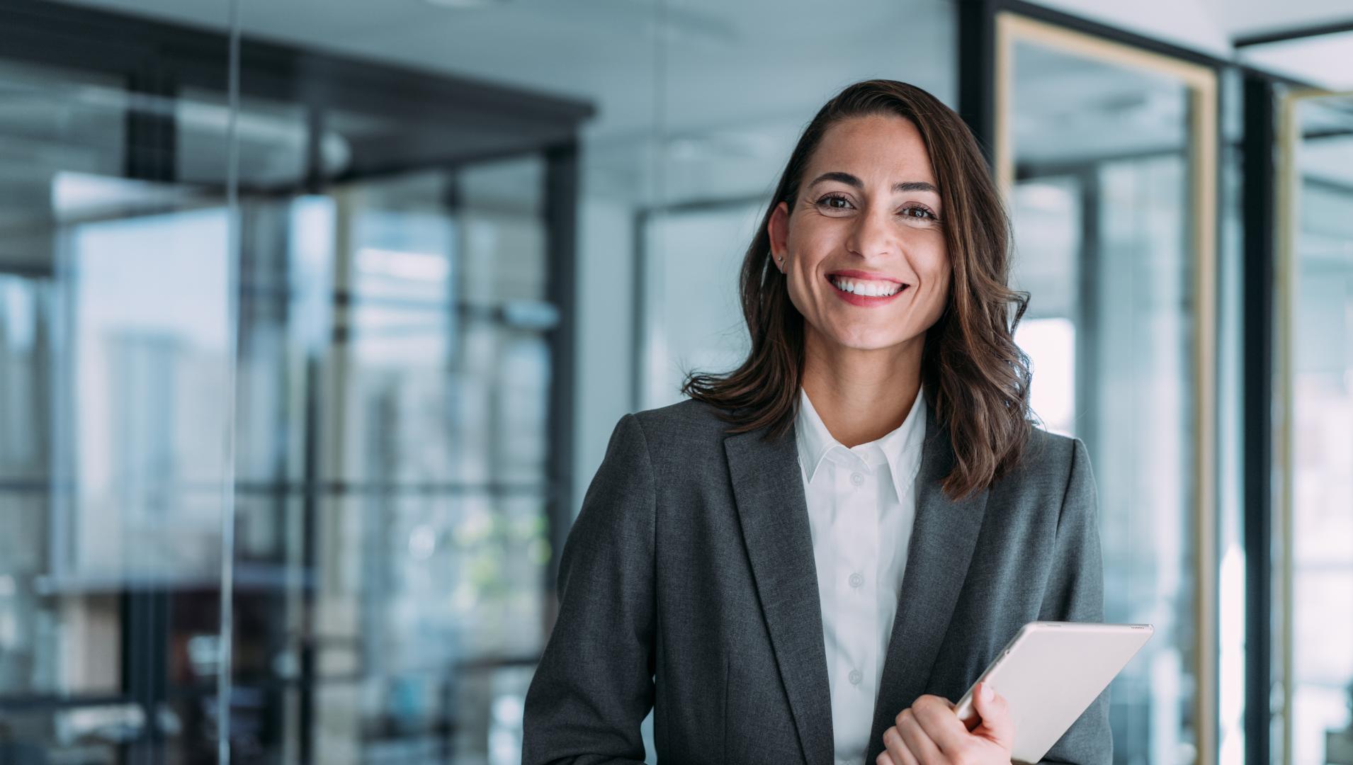 A woman in a business suit smiles in an office