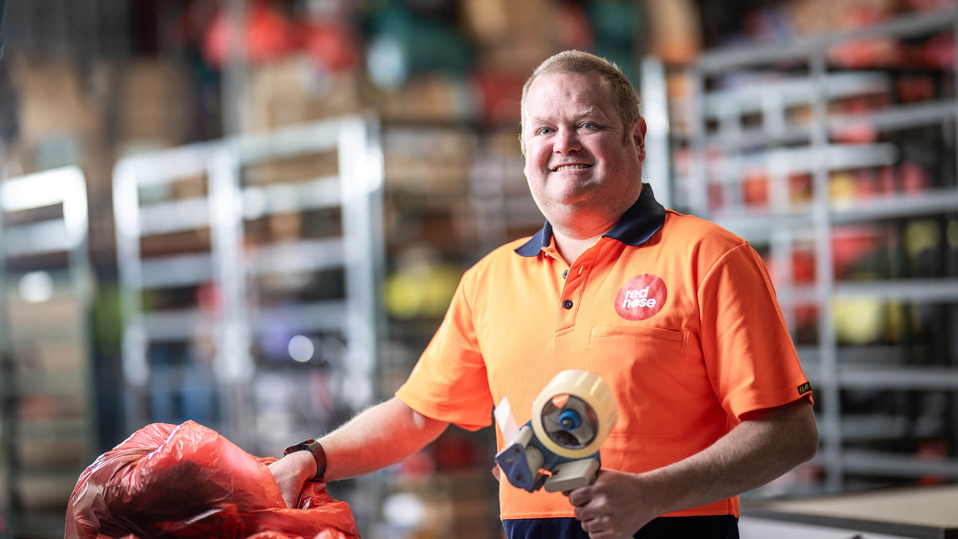 A DES participant smiles in an orange top at work