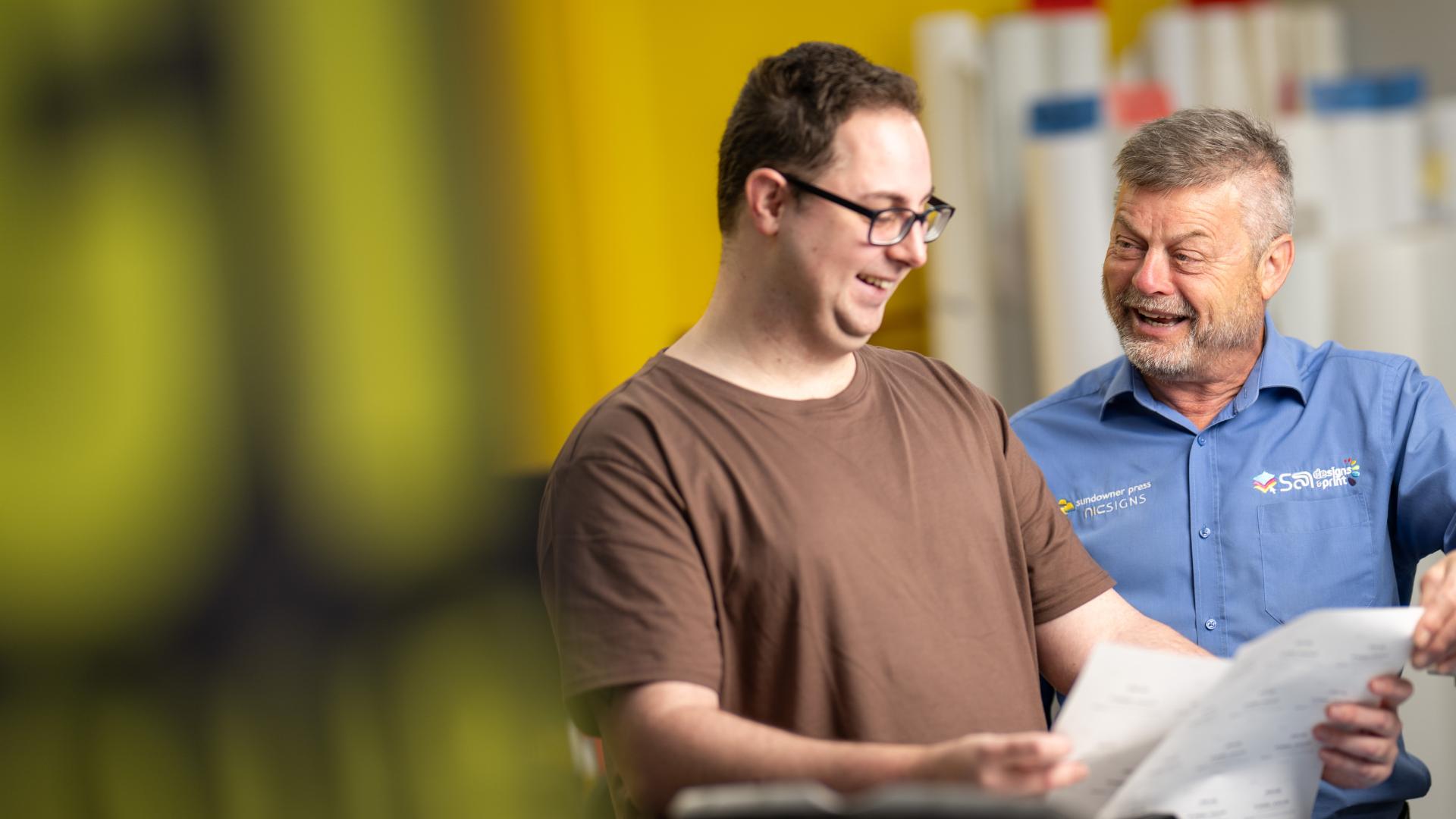 APM consultant in a black polo smiles outside