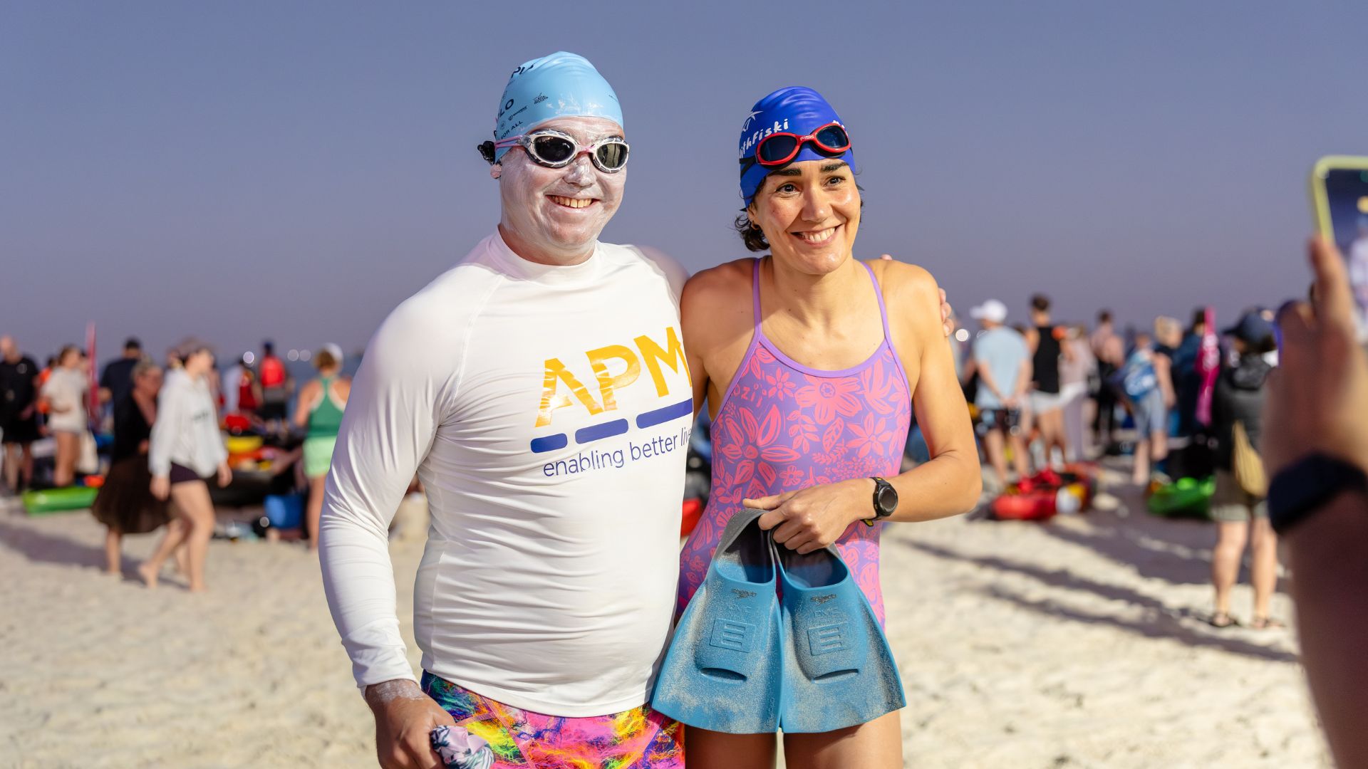 Jeremy McClure and a support swimmer prepare on the beach before an ocean swim, highlighting the teamwork required for long-distance open water challenges.