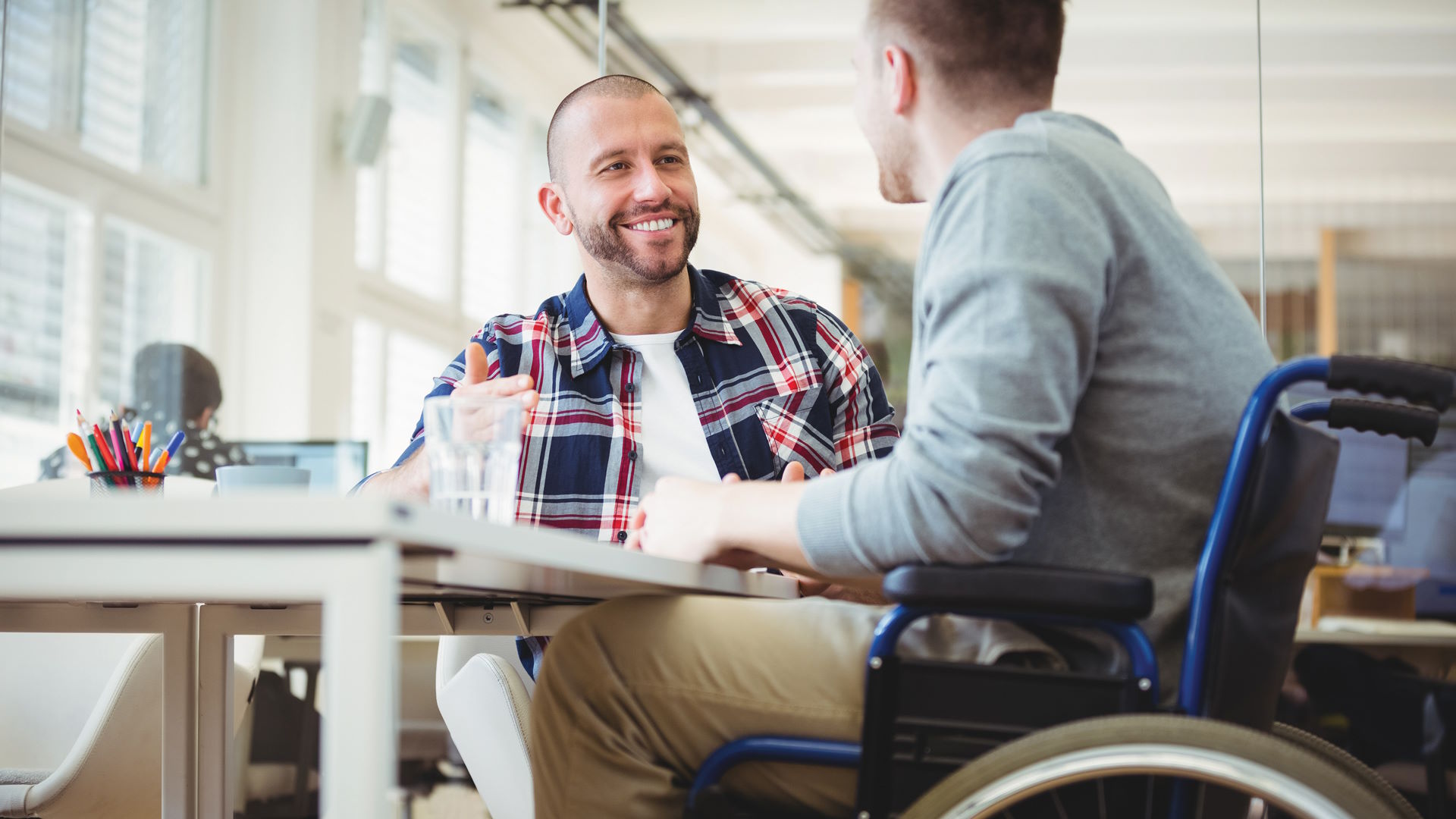 man in a wheelchair talks with another man