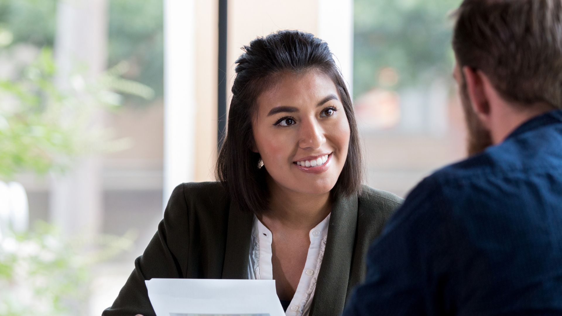 Woman speaking to man in office