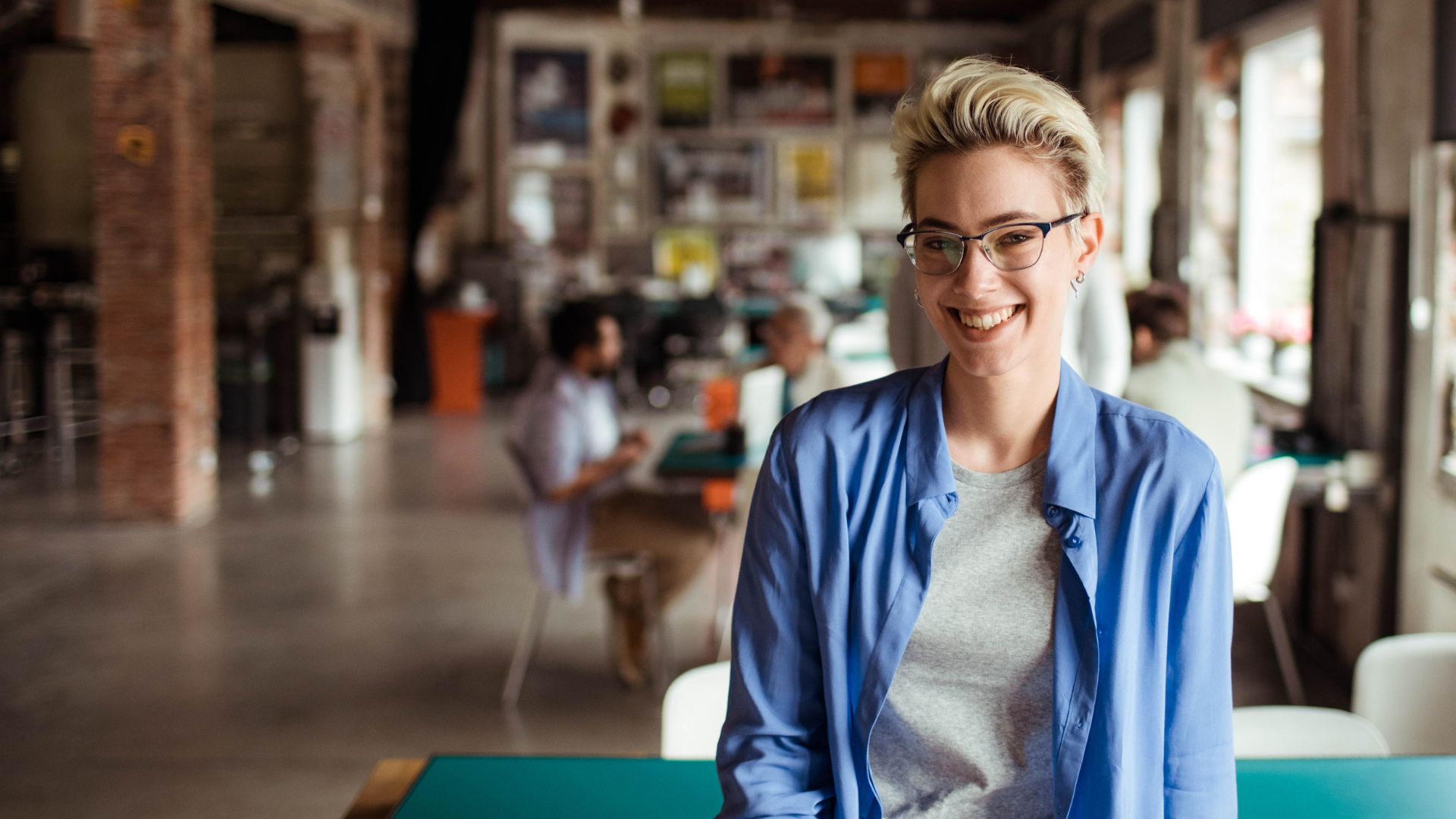 Woman with glasses smiles to show good workplace mental health