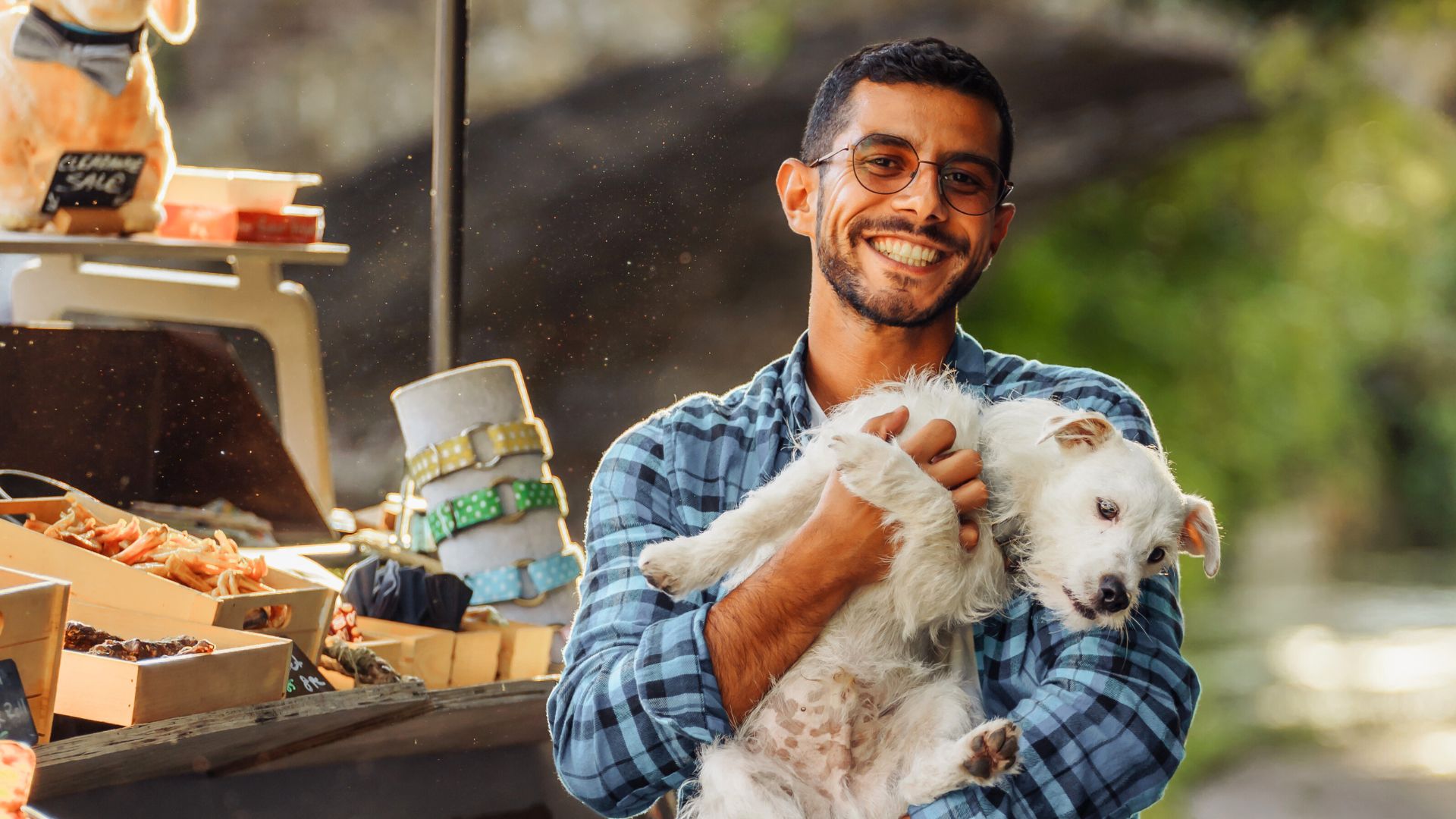 AA man smiles holding a white dog