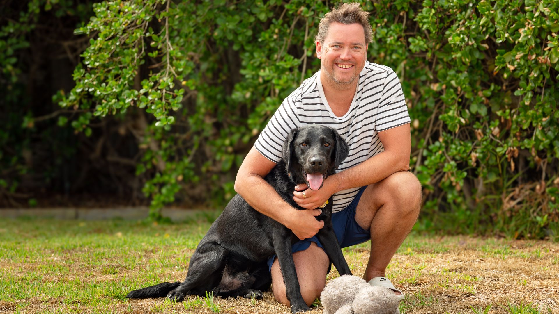 Paralympian swimmer Jeremy McClure with his guide dog outdoors, highlighting life beyond competition and his journey as a legally blind athlete.
